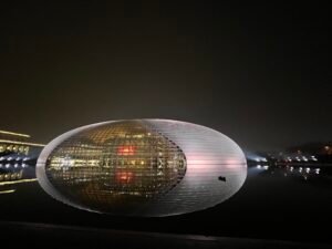 Beyond the Architecture: National Centre for the Performing Arts (NCPA Beijing), a Cultural Engine The National Centre for the Performing Arts (NCPA) in Beijing illuminated at night, reflecting beautifully on the surrounding artificial lake.
